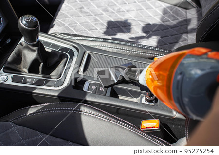 Cleaning a modern car interior with a vacuum cleaner from dirt and dust, background. Equipment Cleaning a modern car interior with a vacuum cleaner from dirt and dust, background. Equipment 95275254