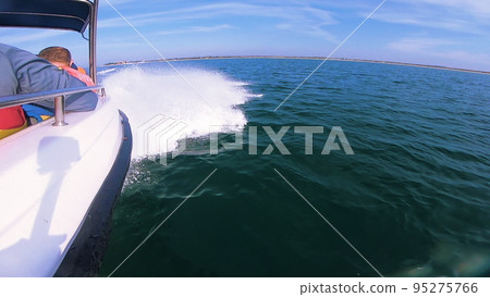 Boat jumping on waves on sunny summer day. Yacht motor boat sailing fast at sea. Extreme sport entertainment background Boat jumping on waves on sunny summer day. Yacht motor boat sailing fast at sea. Extreme sport entertainment background 95275766