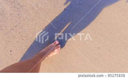 Girl with bare feet walking on water on sandy beach of sea and splashes water her feet on summer sunny day. Barefoot on sand beach. Vacation enjoyment rest relax travel tourism holiday. Slow motion Girl with bare feet walking on water on sandy beach of sea and splashes water her feet on summer sunny day. Barefoot on sand beach. Vacation enjoyment rest relax travel tourism holiday. Slow motion 95275838