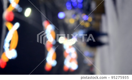 Blurred background. City street during snowfall at winter night. Beautiful illumination and decoration on street. New Year Christmas holidays celebration. Lanterns garlands on trees. Vertical video 95275935