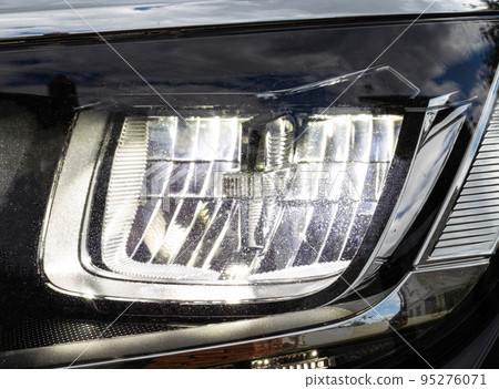 Economical and modern car headlight with LED adaptive light. Close-up, illuminate Economical and modern car headlight with LED adaptive light. Close-up, illuminate 95276071