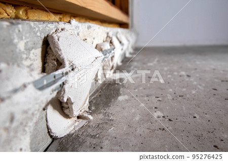 Leveling the walls with a plaster mixture and metal beacons. Plastering of concrete walls during apartment renovation. Close-up 95276425