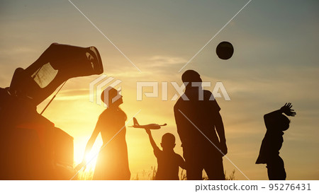 Schoolboy silhouette spending time with family throws ball 95276431