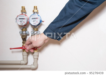 A man turns off a hot water faucet. Planned shutdown of hot water and repair of the heating main. Copy space for text 95276439