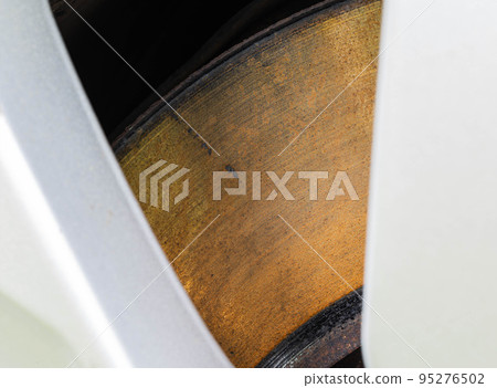 Rusty, defective brake disc with a shoulder on the edge. Worn brake disc concept, brake failure, macro 95276502