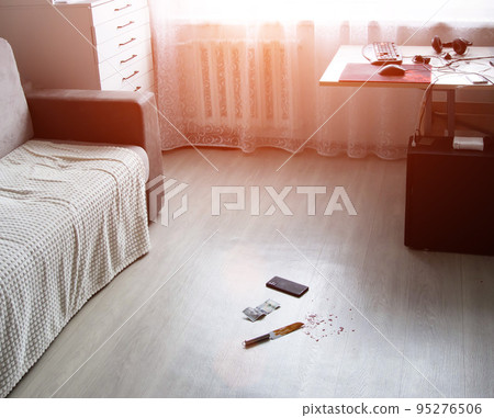 The scene of the crime in the room of the apartment. Knife in blood, money dollars and smarfton lie on the floor. Robbery and theft, crime, evidence 95276506