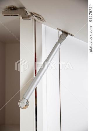 Retractable gas shock absorber for opening the drawer in the kitchen. furniture fittings, close-up 95276734