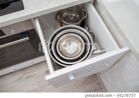 Modern drawers in the kitchen for storing utensils. Kitchen making, close-up Modern drawers in the kitchen for storing utensils. Kitchen making, close-up 95276737