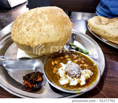 Indian street food called chole bhature at restaurant in delhi 95277762