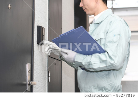 一名工人在入口前推著對講機 一名工人在入口前推著對講機 95277819