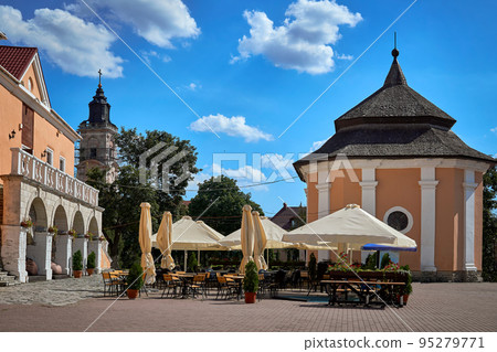 Summer open-air cafe with umbrellas and flowers on a medieval square Summer open-air cafe with umbrellas and flowers on a medieval square 95279771