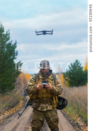 The mercenary launches a reconnaissance drone. Vertical photo. The mercenary launches a reconnaissance drone. Vertical photo. 95280648