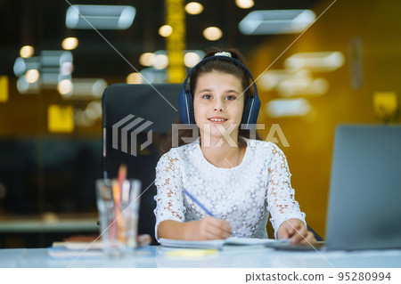 Online education. School girl using laptop computer studying through online e-learning system. 95280994