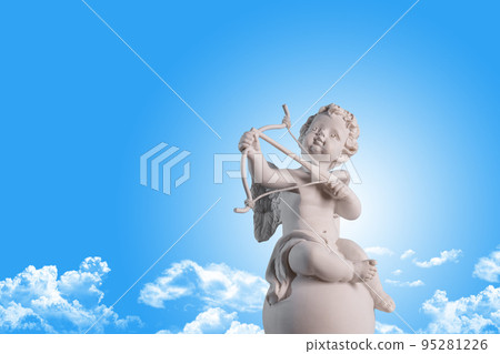 Figurine of an angel Cupid on the podium with a bow and arrow on a blu sky with clouds background . Valentine's Day. Figurine of an angel Cupid on the podium with a bow and arrow on a blu sky with clouds background . Valentine's Day. 95281226