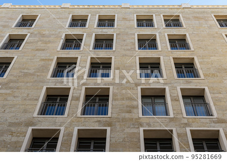 Black long thin rectangular windows in the new building. Many windows dark brown color on the house Black long thin rectangular windows in the new building. Many windows dark brown color on the house 95281669