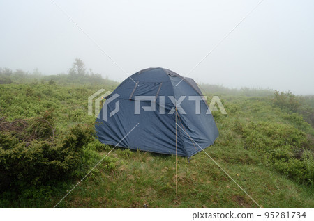 Lonely tent in the fog in the mountains, Carpathians of Ukraine and rest. Lonely tent in the fog in the mountains, Carpathians of Ukraine and rest. 95281734