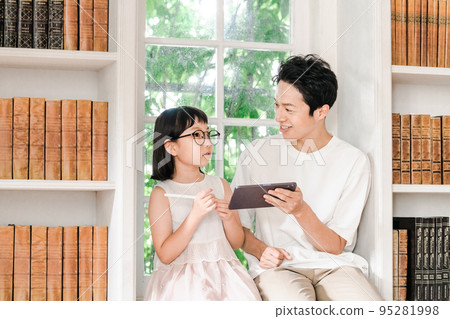 一位父親看著一個小學女生學習 95281998