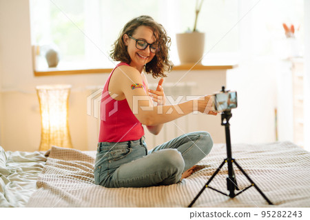 Woman blogger videotapes her vlog at home and speaking about Vaccine for covid-19. 95282243