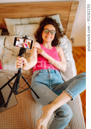 Woman blogger videotapes her vlog at home and speaking about Vaccine for covid-19. Woman blogger videotapes her vlog at home and speaking about Vaccine for covid-19. 95282250