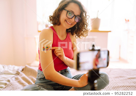 Woman blogger videotapes her vlog at home and speaking about Vaccine for covid-19. 95282252