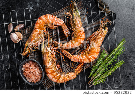 Grilled Giant Black tiger shrimps prawns on grill. Black background. Top view 95282922