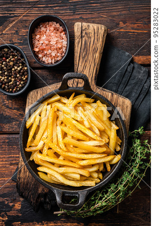 Skilet full of Potato french fries with salt. Wooden background. Top view Skilet full of Potato french fries with salt. Wooden background. Top view 95283022