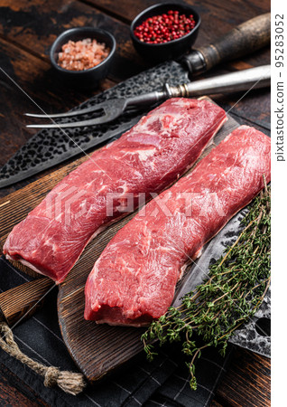 Raw lamb tenderloin fillet, Mutton fresh meat on butcher wooden board. Wooden background. Top view Raw lamb tenderloin fillet, Mutton fresh meat on butcher wooden board. Wooden background. Top view 95283052