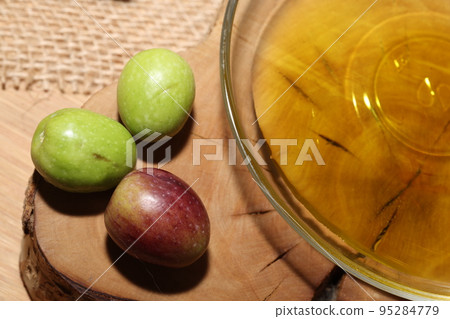 Olives and Olive Oil on wooden background 95284779