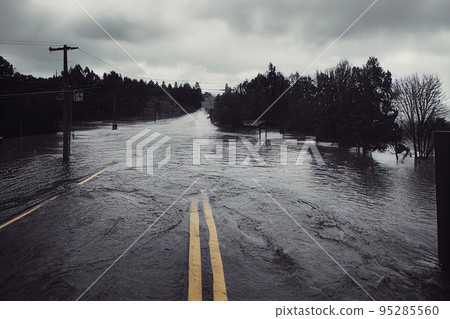 If it's flooded forget it. Flood water covers a road making it impassable. Illustration. 95285560
