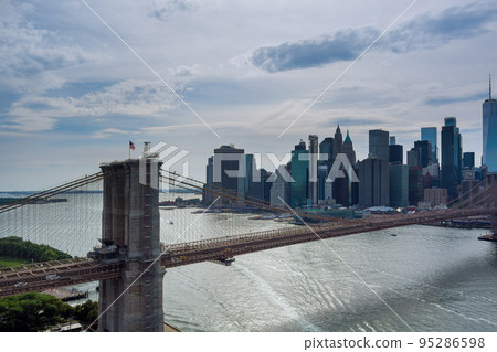 It is panoramic aerial view of Manhattan in the background along East River with picturesque Brooklyn Bridge 95286598
