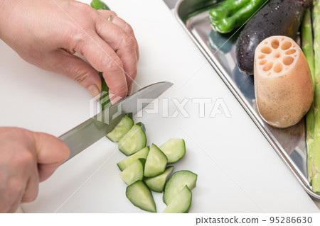 [Cucumber is cut into pieces with a Santoku knife] 95286630