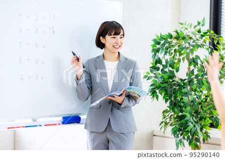 Elementary school students taking classes using a whiteboard 95290140