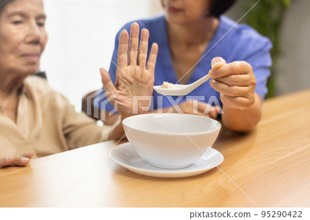 Senior asian woman bored with food. Senior asian woman bored with food. 95290422