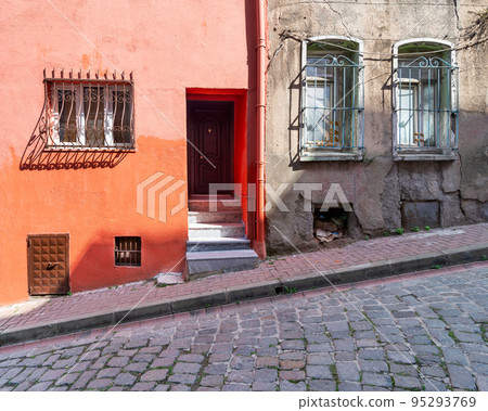 Old house painted in orange, and wrought iron windows, at a cobblestone street, Balat district, Istanbul, Turkey Old house painted in orange, and wrought iron windows, at a cobblestone street, Balat district, Istanbul, Turkey 95293769