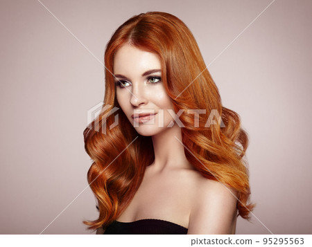 Redhead woman with curly hair 95295563