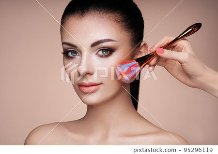 Beautiful Woman applies Skin Tone with Brush 95296119