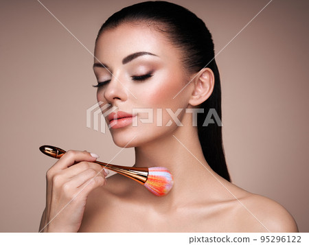 Beautiful Woman applies Skin Tone with Brush 95296122