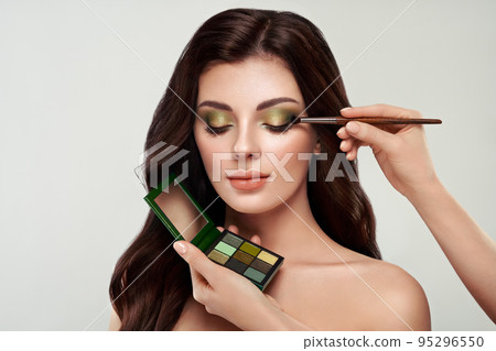 Makeup artist applies eye shadow Makeup artist applies eye shadow 95296550