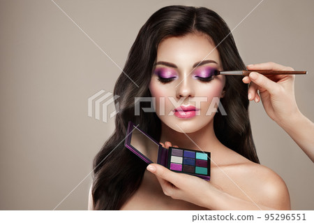 Makeup artist applies eye shadow Makeup artist applies eye shadow 95296551