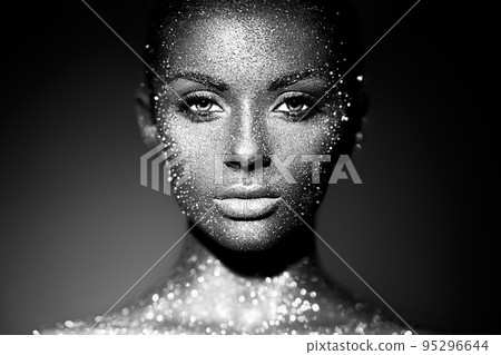 Portrait of beautiful woman with sparkles on her face 95296644