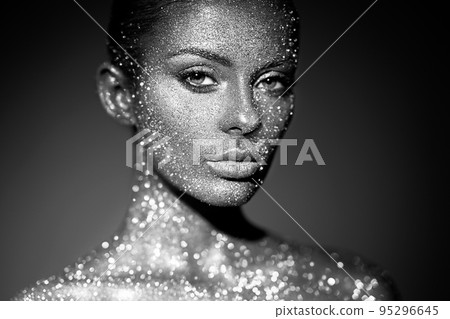 Portrait of beautiful woman with sparkles on her face Portrait of beautiful woman with sparkles on her face 95296645