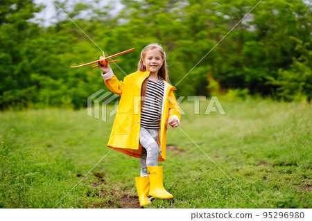 Cute little girl launches a toy airplane into the sky. A child walks in the field. Childhood and healthy lifestyle. Cute little girl launches a toy airplane into the sky. A child walks in the field. Childhood and healthy lifestyle. 95296980