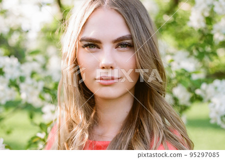 Beautiful young woman in summer garden 95297085