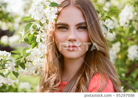 Beautiful young woman in summer garden 95297086