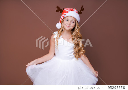 Happy funny child girl in red christmas deer costume smiling looking at camera. 95297358
