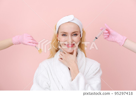 Close-up portrait thoughtful woman hands in medical gloves hold syringe 95297418