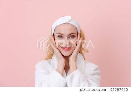 Beauty woman face portrait. Blond woman looks at camera and smiles in a white Beauty woman face portrait. Blond woman looks at camera and smiles in a white 95297420