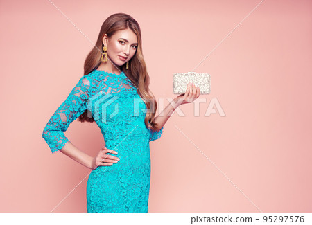 Blonde young woman in elegant turquoise dress Blonde young woman in elegant turquoise dress 95297576