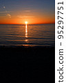 The sun on the horizon and the light trails reflected on the sea surface 95297751