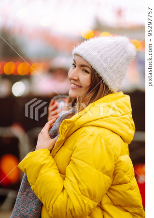 Happy woman ice skating on the ice arena in the city square on Festive Christmas fair. Cold weather. 95297757